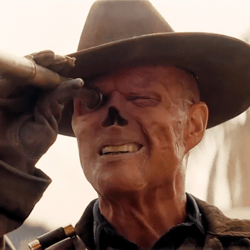 A Man With A Skull Painted On His Face Is Wearing A Cowboy Hat And Holding A Gun GIF