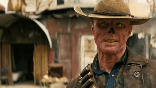 A Man With A Skull Painted On His Face Wearing A Cowboy Hat GIF