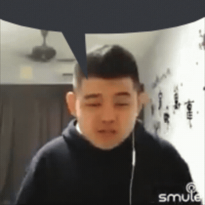 A Man With A Speech Bubble Above His Head Is Wearing Headphones And Looking At The Camera . GIF
