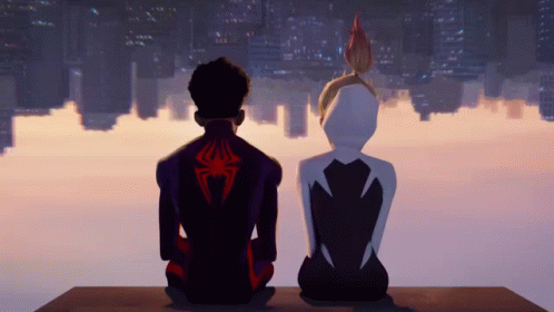 A Man With A Spider On His Back Sits Next To A Woman With White Hair GIF
