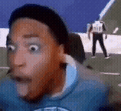 A Man With A Surprised Look On His Face Is Sitting In Front Of A Computer . GIF