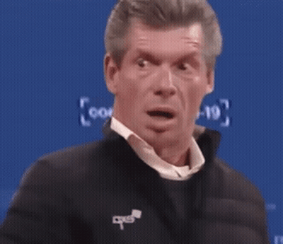 A Man With A Surprised Look On His Face Is Standing In Front Of A Blue Screen . GIF
