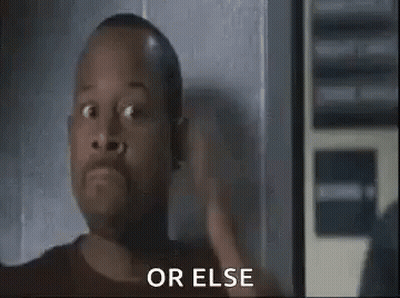 A Man With A Surprised Look On His Face Is Standing In Front Of A Wall . GIF