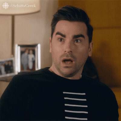 A Man With A Surprised Look On His Face Is Wearing A Black Shirt With White Stripes GIF
