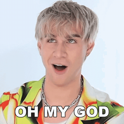 A Man With A Surprised Look On His Face Is Wearing A Colorful Shirt And A Chain Necklace . GIF