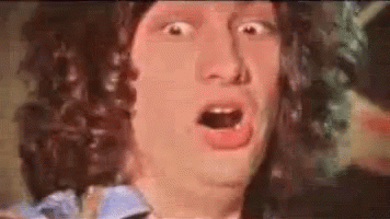 A Man With A Surprised Look On His Face Is Wearing A Wig . GIF