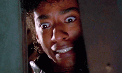A Man With A Surprised Look On His Face Looks Through A Door GIF