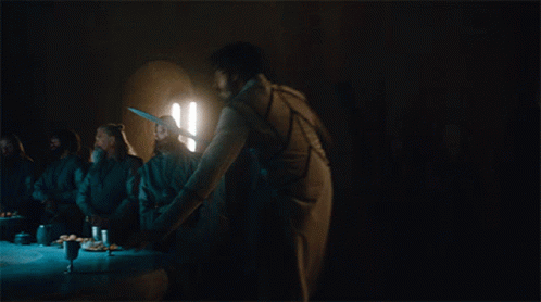 A Man With A Sword Is Standing On A Table In A Dark Room GIF