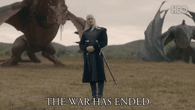 A Man With A Sword Stands In A Field With Dragons And The Words The War Has Ended Below Him GIF