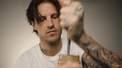 A Man With A Tattoo On His Arm Holds A Jar GIF
