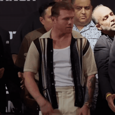A Man With A Tattoo On His Arm Is Standing In A Crowd Of People GIF