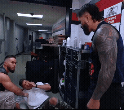 A Man With A Tattoo On His Arm Is Standing In Front Of A Sign That Says Training Room GIF