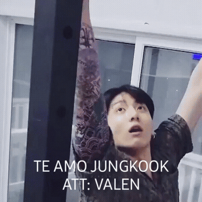 A Man With A Tattoo On His Arm Is Standing In Front Of A Window With His Arms Outstretched . GIF