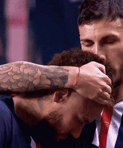 A Man With A Tattoo On His Arm Is Touching Another Man 'S Head . GIF
