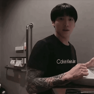 A Man With A Tattoo On His Arm Is Wearing A Black Calvin Klein Shirt GIF
