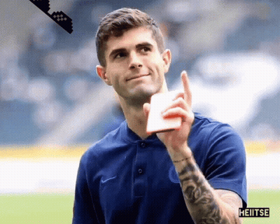 A Man With A Tattoo On His Arm Is Wearing A Blue Shirt That Says Heiitse GIF