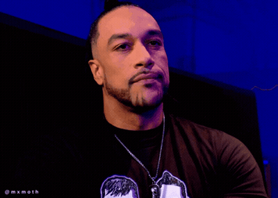A Man With A Tattoo On His Arm Is Wearing A T-Shirt With A Picture Of Two Men On It GIF
