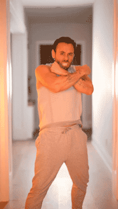 A Man With A Tattoo On His Arm Stands In A Hallway With His Arms Crossed GIF