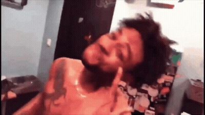 A Man With A Tattoo On His Chest Is Giving The Middle Finger GIF