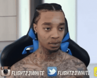 A Man With A Tattoo On His Chest Is Sitting In A Chair With Flight23white Written On The Bottom Right GIF