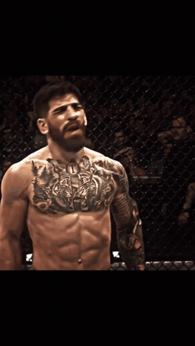 A Man With A Tattoo On His Chest Is Standing In Front Of A Sign That Says Pro.com GIF