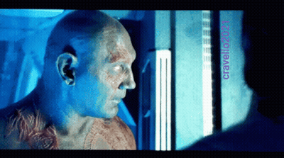 A Man With A Tattoo On His Chest Looks At Another Man With The Name Cravello2021 On The Bottom GIF