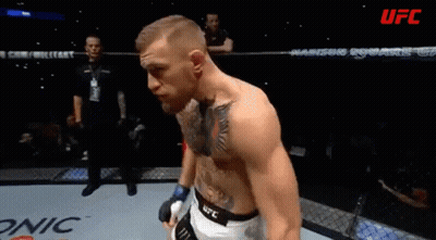 A Man With A Tattoo On His Chest Stands In A Boxing Ring With Ufc Written On The Bottom GIF