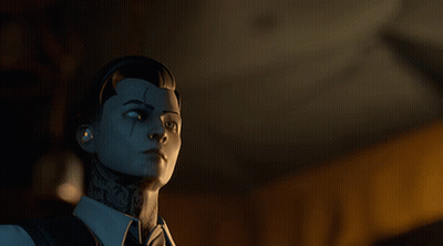 A Man With A Tattoo On His Face Is Looking At Something In A Dark Room GIF