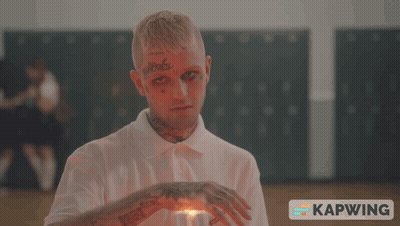 A Man With A Tattoo On His Forehead Holds A Lighter In His Hand GIF