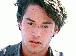 A Man With A Tattoo On His Forehead Is Looking At The Camera . GIF