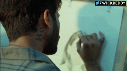 A Man With A Tattoo On The Back Of His Neck Is Drawing GIF
