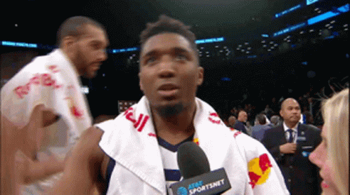 A Man With A Towel Around His Neck And A Microphone That Says At & T Sportsnet On It GIF