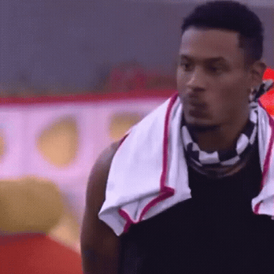 A Man With A Towel Around His Neck Is Looking At Something . GIF