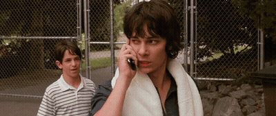 A Man With A Towel Around His Neck Is Talking On His Cell Phone GIF