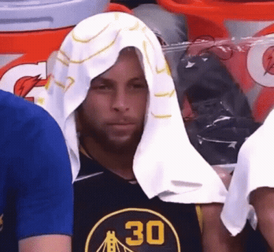A Man With A Towel Wrapped Around His Head Is Wearing A Golden State Warriors Shirt . GIF