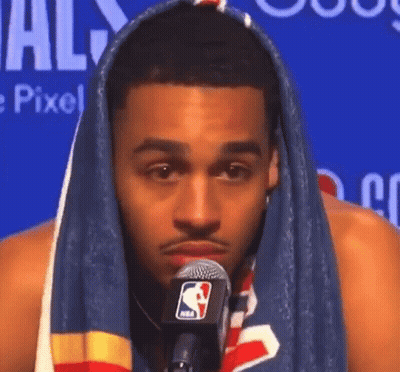 A Man With A Towel Wrapped Around His Head Talking Into A Microphone . GIF