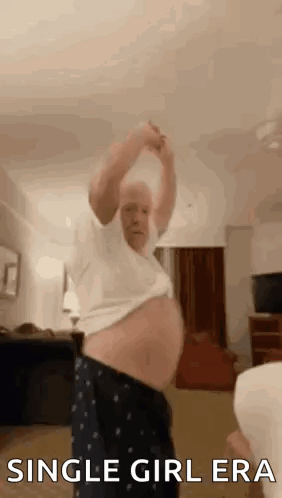 A Man With A Very Large Belly Is Dancing In A Living Room With His Arms In The Air . GIF