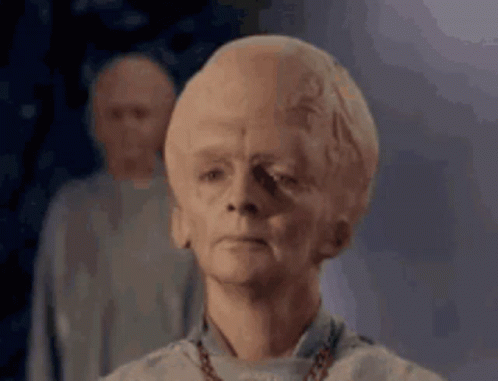 A Man With A Very Large Head Is Standing In Front Of Two Other Men GIF
