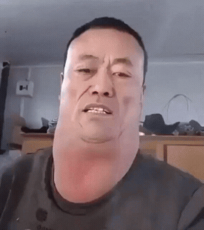 A Man With A Very Large Neck Is Making A Funny Face While Looking At The Camera . GIF