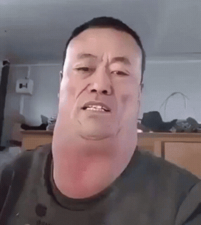 A Man With A Very Large Neck Is Making A Funny Face While Looking At The Camera . GIF