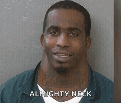 A Man With A Very Large Neck Is Smiling In A Mug Shot . GIF