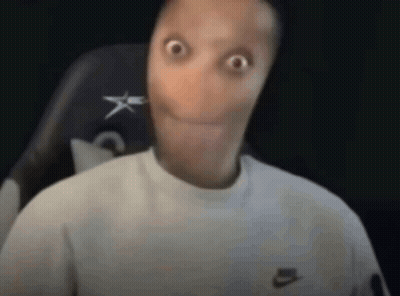 a man with a very long face is sitting in a chair and making a surprised face .