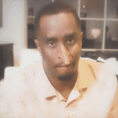 A Man With A Very Long Nose Is Wearing An Orange Shirt GIF