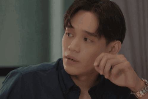 A Man With A Watch On His Wrist Has His Hand On His Face GIF