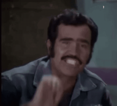 a man with a watch on his wrist is making a funny face with his fist .