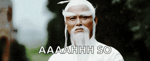 A Man With A White Beard And A Feather In His Hair Says Aaahhh So GIF
