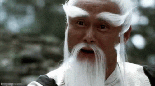A Man With A White Beard And Mustache Is Looking At The Camera . GIF