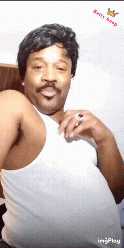 A Man With A Wig And Mustache Is Wearing A White Tank Top With The Words Betty Boop On The Bottom GIF