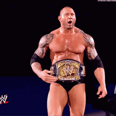 A Man With A Wrestling Belt Is Standing In Front Of A Screen That Says ' Wrestlemania ' On It GIF