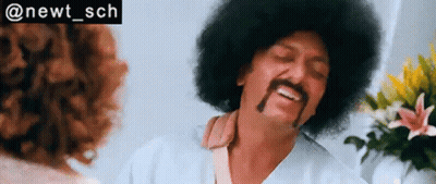 A Man With An Afro And Mustache Is Talking To A Woman In A Room . GIF
